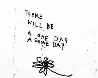 May include: A black and white print featuring the hand-lettered text THERE WILL BE A ONE DAY A SOME DAY above a simple line drawing of a single flower with petals and a stem. The design has a textured, ink-stamped appearance on a white background.