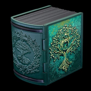 May include: A green and gold decorative box with a tree of life design. The box is made of wood and has a hinged lid.