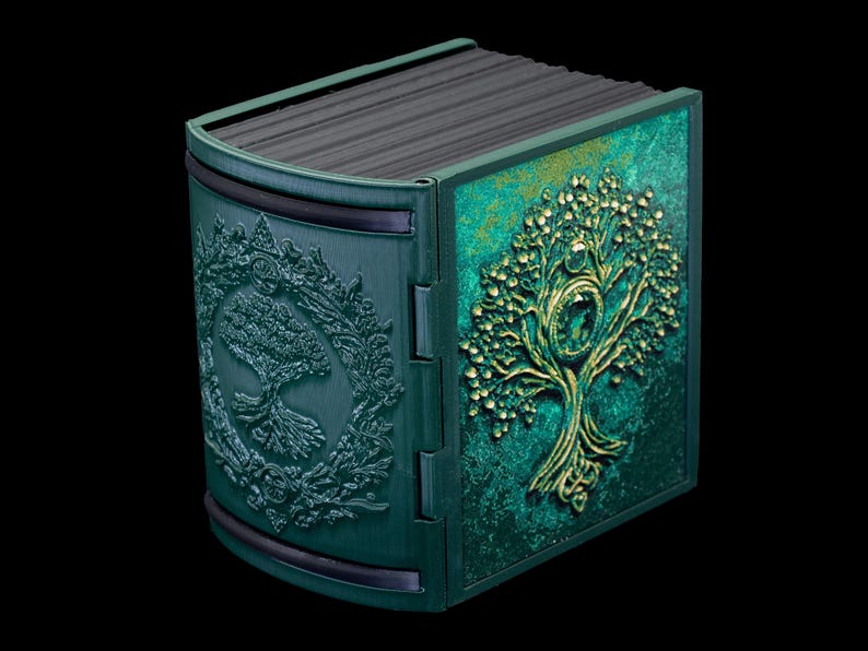 May include: A green and gold decorative box with a tree of life design. The box is made of wood and has a hinged lid.