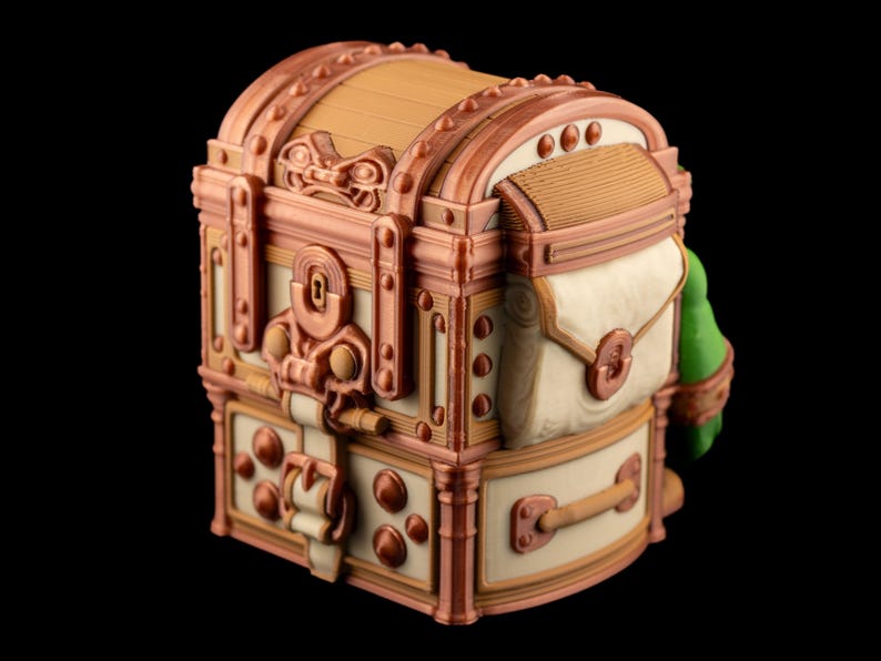 May include: A detailed, decorative treasure chest with a domed lid. The chest features a combination of cream, copper, and tan colors, with intricate hardware and a small attached bag. The design suggests a vintage or fantasy theme.