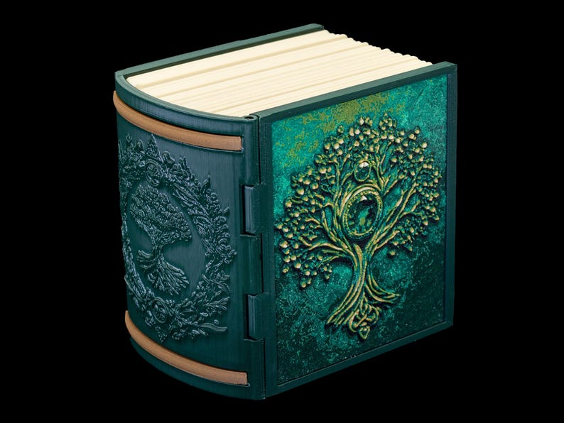 May include: A green book with a gold embossed tree design on the cover. The book is closed and has a decorative wooden spine.
