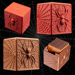 May include: Four decorative boxes featuring a spider and web design. The boxes are in shades of red and brown, with a spider and web pattern carved into the sides. One box is open, revealing a stack of wooden cards.