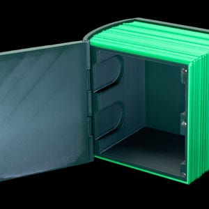 May include: A green and black box with a hinged lid that opens to reveal an empty interior. The box is made of a textured material and has a modern design.