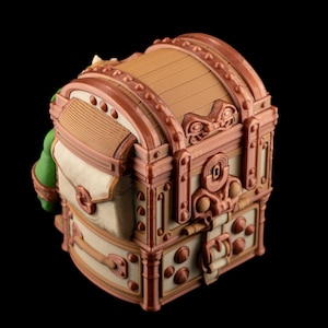 May include: A detailed, decorative treasure chest with a domed lid. The chest features a combination of tan, brown, and cream colors, with ornate metal-like accents. The design includes rivets, a keyhole, and a clasp, suggesting a vintage or fantasy theme.