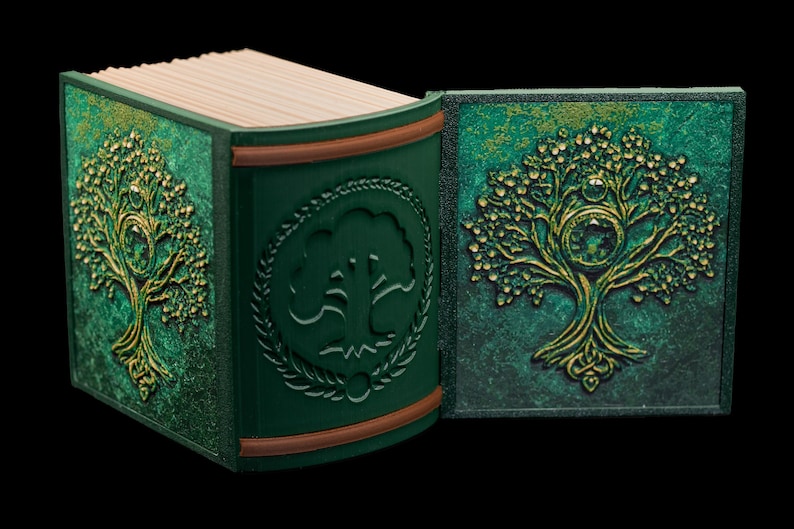 May include: A green leather-bound journal with a gold embossed tree design on the cover. The journal is open to reveal blank pages.