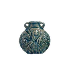 May include: A teal ceramic pendant with a fairy design. The pendant is round with two small holes at the top and features a relief carving of a fairy with wings, sitting among foliage. The fairy is wearing a hat.