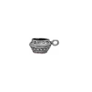 Puede incluir: Encanto de plata en forma de una pequeña olla adornada con asa. La olla tiene un diseño detallado con un borde elevado y una superficie texturizada.