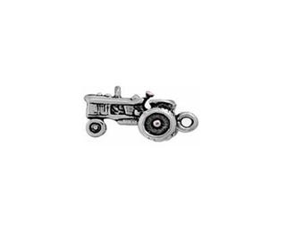 May include: Silver charm of a detailed tractor with a loop for attaching to a bracelet or necklace.