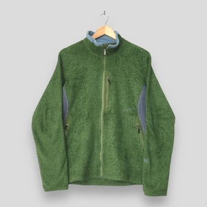 May include: A green textured fleece jacket with a full-length front zipper, a high collar with light blue interior lining, a vertical zippered chest pocket, and two side zippered pockets. The jacket features grey side panels and long sleeves.