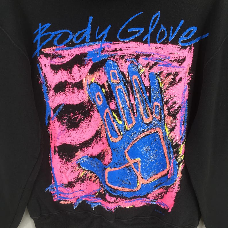 May include: Black sweatshirt with a vibrant graphic featuring a blue handprint within a pink and blue rectangular design. The words "Body Glove" are written above the handprint in blue. The sweatshirt is a casual apparel item.
