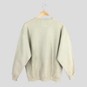 Peut inclure: Un sweat-shirt vert clair &agrave; col rond et manches longues.