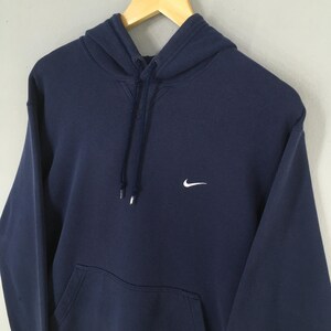 Pu&ograve; includere: Felpa con cappuccio blu navy con logo Nike bianco sul petto. La felpa con cappuccio ha un cordino e una tasca frontale. Il capo &egrave; realizzato in materiale morbido ed &egrave; adatto per un abbigliamento casual.
