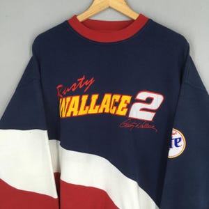 May include: Navy blue sweatshirt with red and white accents. Features the text "Rusty Wallace 2" in yellow and white, with a signature. A Miller Lite logo is on the sleeve. Vintage style.
