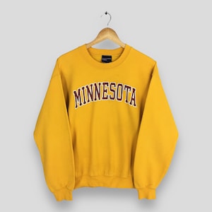 May include: A white ceramic mug with a black handle and the text "But First, Coffee" in a bold, black font. The mug is set against a neutral background, highlighting its simple design.