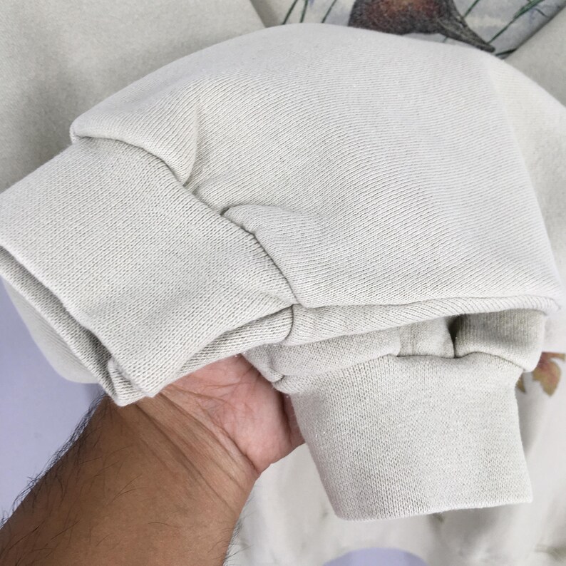 Peut inclure: Un sweat-shirt gris clair avec un poignet c&ocirc;tel&eacute;. Le sweat-shirt est fait d'un tissu doux et confortable.