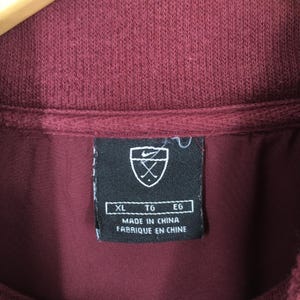 May include: A white ceramic mug with a black handle and the text "But First, Coffee" in a black, bold font. The mug is on a white surface.