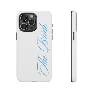 May include: White smartphone case with a black camera module and black side buttons. The case has the light blue cursive text "The Bride" vertically on the back. The case is designed for a mobile phone.