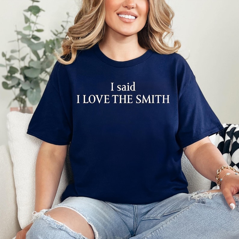 May include: A navy blue t-shirt with white text that reads "I said I LOVE THE SMITH".
