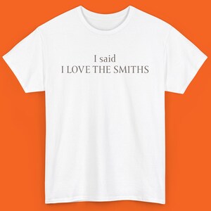 May include: White t-shirt with the text "I said I LOVE THE SMITHS" printed in grey on the front.