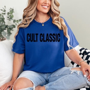 May include: A royal blue t-shirt with the text "CULT CLASSIC" printed in black.