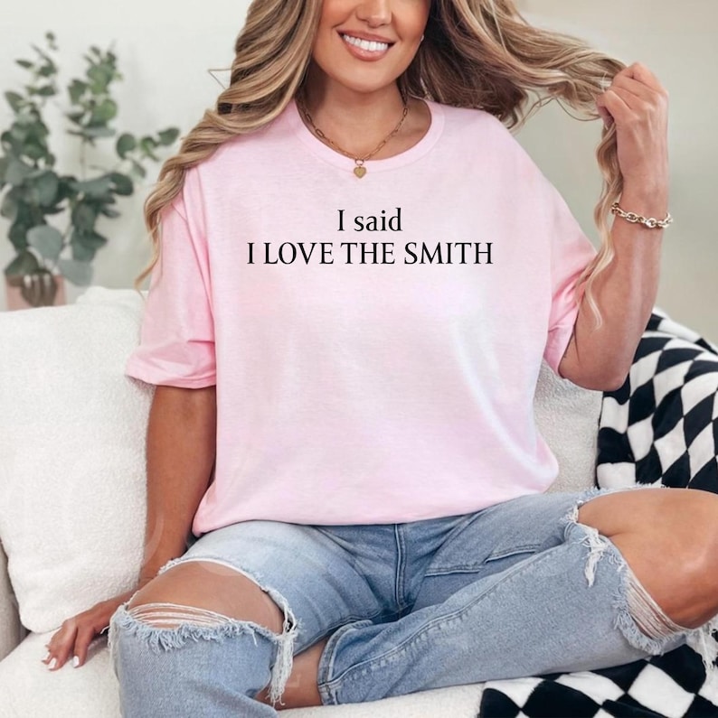 May include: A pink t-shirt with the text "I said I LOVE THE SMITH" printed on the front.