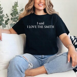 May include: A black t-shirt with white text that reads "I said I LOVE THE SMITH".