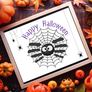 Pode incluir: Uma impressão emoldurada com tema de Halloween com uma aranha de desenho animado em uma teia, com as palavras "Happy Halloween" em roxo. A impressão é cercada por abóboras e folhas de outono.