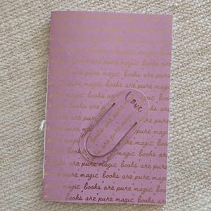 A handmade Bible study journal with a faith-inspired design. The cover features hand-lettered scripture, floral accents, and soft pastel tones. Inside, the journal includes lined, dotted, and blank pages for note-taking, prayer journaling, and reflection. Divider tabs help organize scripture studies, sermon notes, and daily devotions. Ideal for personal use or gifting, this thoughtful journal encourages spiritual growth and creativity.