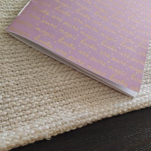 A handmade Bible study journal with a faith-inspired design. The cover features hand-lettered scripture, floral accents, and soft pastel tones. Inside, the journal includes lined, dotted, and blank pages for note-taking, prayer journaling, and reflection. Divider tabs help organize scripture studies, sermon notes, and daily devotions. Ideal for personal use or gifting, this thoughtful journal encourages spiritual growth and creativity.