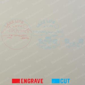 May include: Laser-cut designs with a lake theme. The image features the text "LAKE LIFE" with illustrations of mountains, a lake scene, a dock with chairs, and a campfire. The word "ENGRAVE" is in red, and "CUT" is in blue.