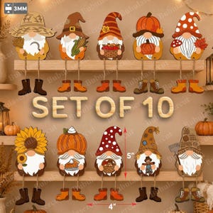 Puede incluir: Un conjunto de 10 adornos de madera con forma de gnomos, de 12,7 cm de alto y 10,16 cm de ancho, con motivos otoñales como calabazas, girasoles y maíz. Los gnomos tienen piernas colgantes con botas y un grosor de 3 mm.