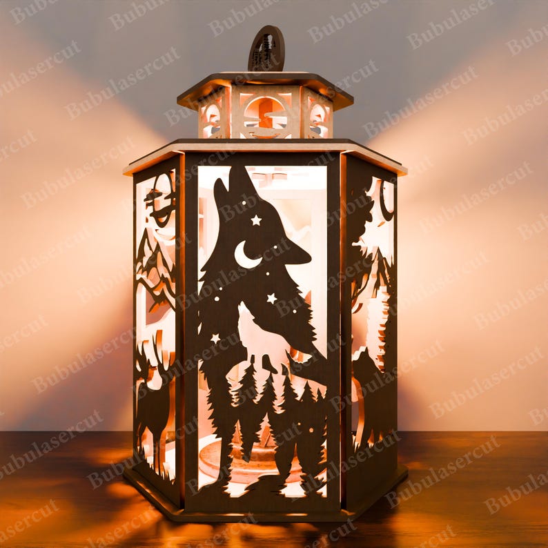May include: A wooden lantern featuring a wolf howling at the moon design. The lantern has a clear glass panel and is illuminated from within, creating a warm glow. The design also includes a crescent moon, stars, and trees.