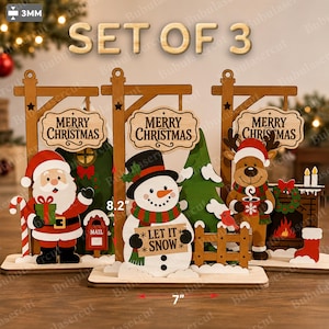 May include: A set of three wooden Christmas decorations, each 8.2 inches tall and 7 inches wide, featuring a Santa Claus, a snowman holding a sign that says LET IT SNOW, and a reindeer. Each piece includes a MERRY CHRISTMAS sign and 3mm thick wood.