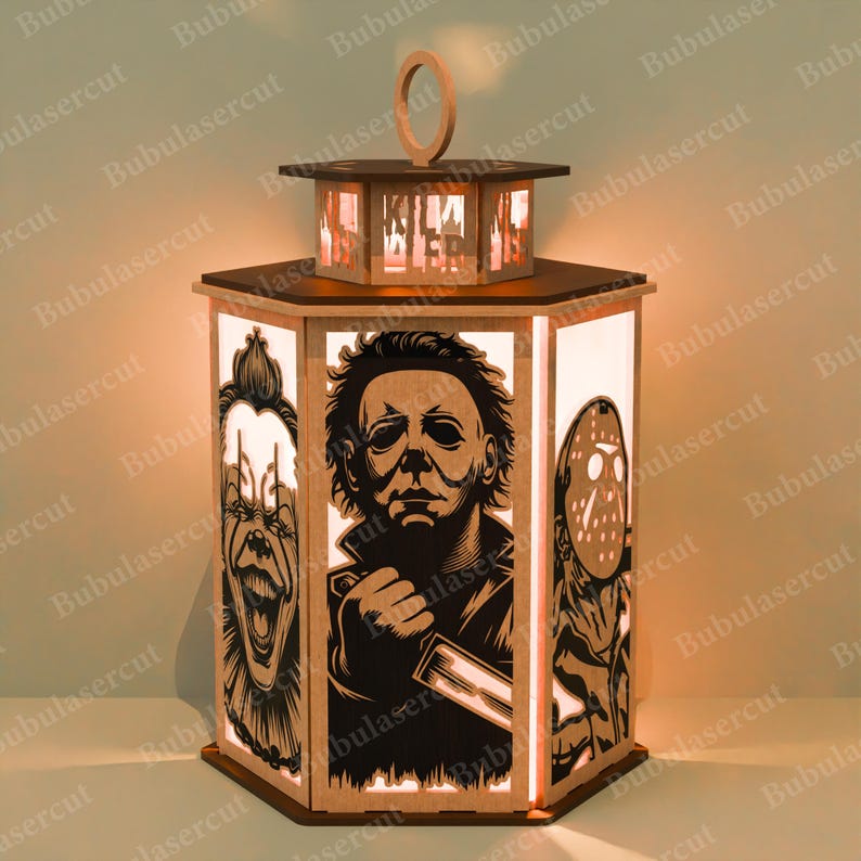 May include: A wooden lantern with a hexagonal base and top, featuring cut-out images of horror movie characters. The lantern has a handle and is illuminated from within, creating a warm glow. The characters include a clown, Michael Myers, and Jason Voorhees.