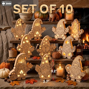 Op de afbeelding: Een set van 10 lasergesneden houten kabouterdecoraties met uitsparingen van bladeren, pompoenen en sterren die van binnenuit oplichten. De figuren zijn 3,2 cm hoog en 2,7 cm breed en staan op een display met meerdere niveaus.