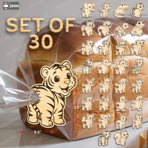 Op de afbeelding: Een set van 30 houten dierenuitsparingen, elk ongeveer 8,9 cm groot. De collectie bevat verschillende dieren zoals een tijger, een olifant en een giraffe. De tekst "SET OF 30" is zichtbaar. De uitsparingen zijn gemaakt van lichtgekleurd hout.