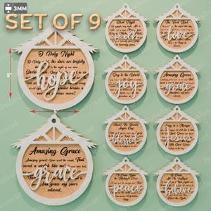 May include: Set of nine Christmas ornaments. Each ornament is 5 inches wide and features a house-shaped frame with a circular center. The centers display Christmas carols and words like "hope", "joy", and "peace".