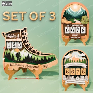 May include: Set of 3 wooden hiking-themed decor pieces. One is a boot-shaped log with "Miles Hiked This Year" counter, another is an arch with a mountain scene and counter, and the last is an arch with a mountain scene and counter. The boot is 10 inches long and 8 inches tall.