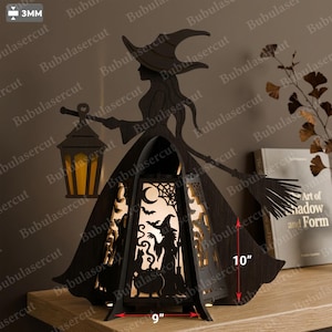 Può includere: Una decorazione a forma di strega in legno marrone scuro tagliato al laser, con lanterna e scopa. La struttura centrale presenta una scena ritagliata con una strega, un calderone, pipistrelli e una luna. Misura 22,86 cm di larghezza e 25,4 cm di altezza.