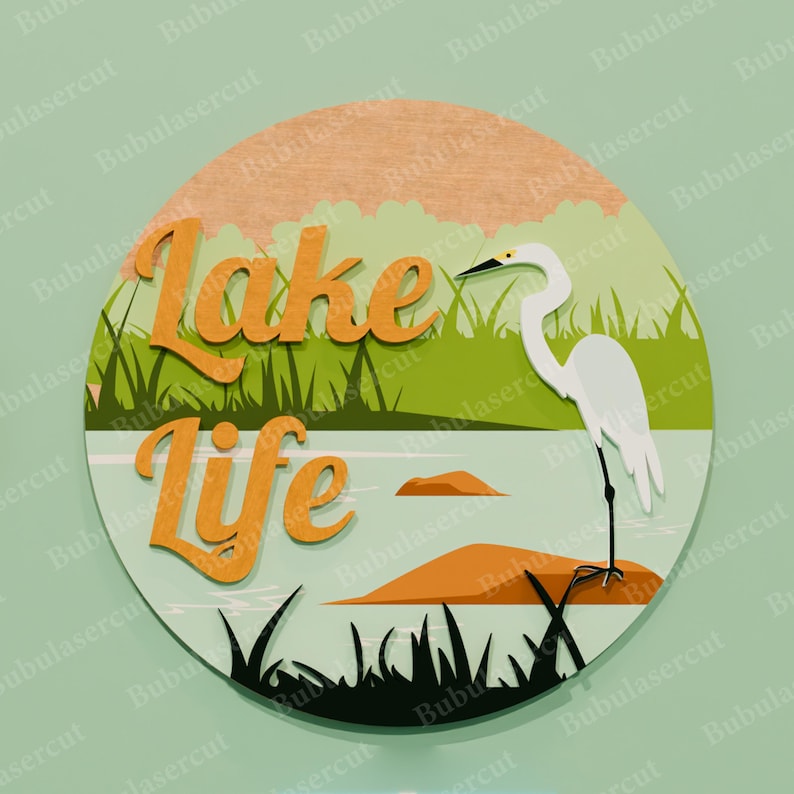May include: A round wooden sign with a lake scene. The sign features the words "Lake Life" in orange, a white heron, and a lake with grass and rocks. The background is green and light blue.
