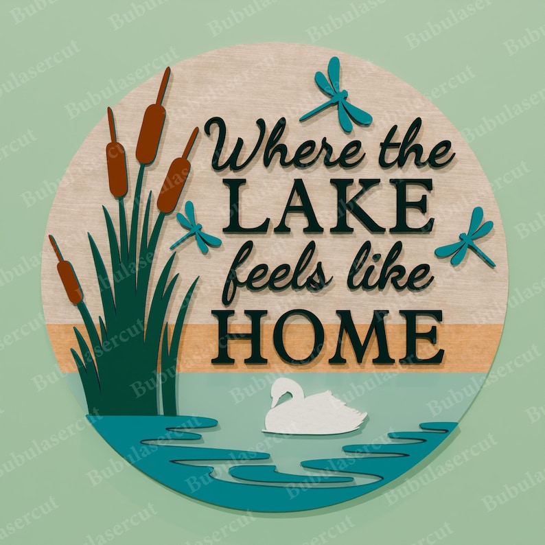 May include: A round wooden sign with the text "Where the LAKE feels like HOME". The sign features a lake scene with cattails, dragonflies, and a swan. The sign is made of wood and has a natural finish.