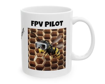 Könnte beinhalten: Weiße Keramiktasse mit einem Schwarzweißbild einer Wespe mit Schutzbrille und dem Text "FPV PILOT" auf einem Wabenhintergrund.