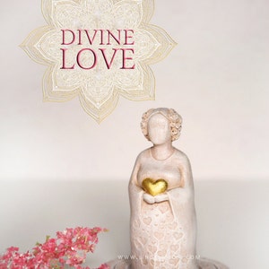 May include: White ceramic figurine of a woman holding a gold heart, with the words "DIVINE LOVE" in a gold mandala above her. The figurine is on a white base with a heart pattern and is surrounded by pink flowers.