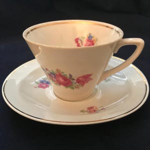Chodziez of Poland 1926-1940s Porcelain Demitasse Tea Cup and Saucer. Cream with Pink and Blue Flowers. Gold Trim. Very Good Condition.