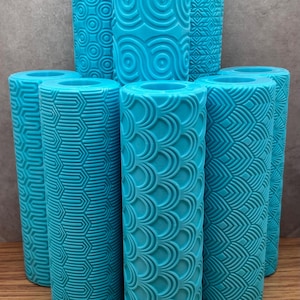 May include: Set of seven blue textured rollers for decorating cakes or other baked goods. The rollers have different patterns, including circles, diamonds, and scales.