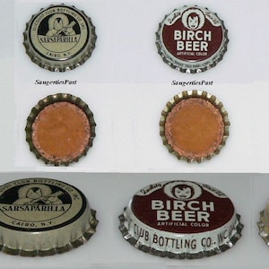 May include: A collection of vintage bottle caps featuring various beverages, including Sarsaparilla, Birch Beer, Golden Ginger Ale, and Root Beer. The caps are in various states of wear and tear, with some showing signs of rust and corrosion.