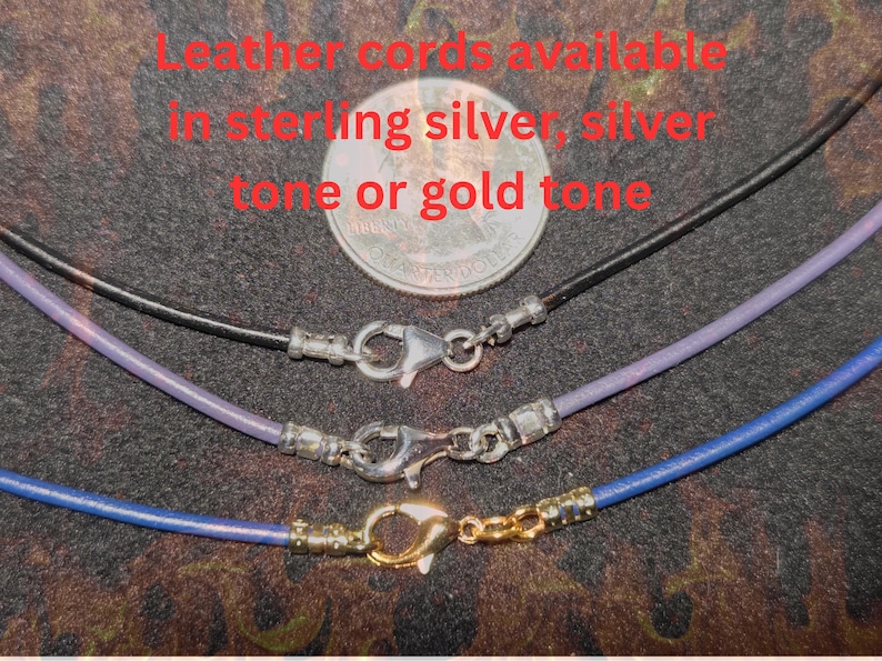 Close-up of leather necklace cords shown with 10mm large lobster claw clasps, displayed in sterling silver, silver tone, and gold tone finishes, with a U.S. quarter above for size reference on a dark textured background.