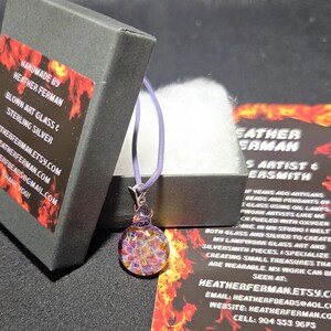Image of the pendant and a jewelry box labeled with the business name. A business bookmark explains the glassmaking process, accompanying the pendant for a complete gift presentation.