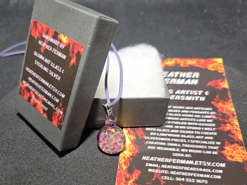 Image of the pendant and a jewelry box labeled with the business name. A business bookmark explains the glassmaking process, accompanying the pendant for a complete gift presentation.