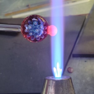 Image of a  pendant being shaped in the flame of a blowtorch.